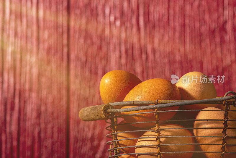 A basket full of farm fresh brown eggs on a straw bale – sunbeam
